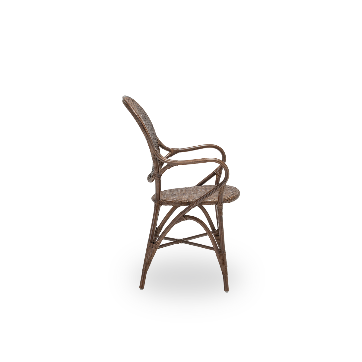 Plain side view of the Rossini dining armchair, in brown rattan. Designed in 1993 by Knud Andreasen of Sika-Design together with Japanese designer Yamakawa, it is the brand's signature chair. Handcrafted from high-quality Indonesian rattan.