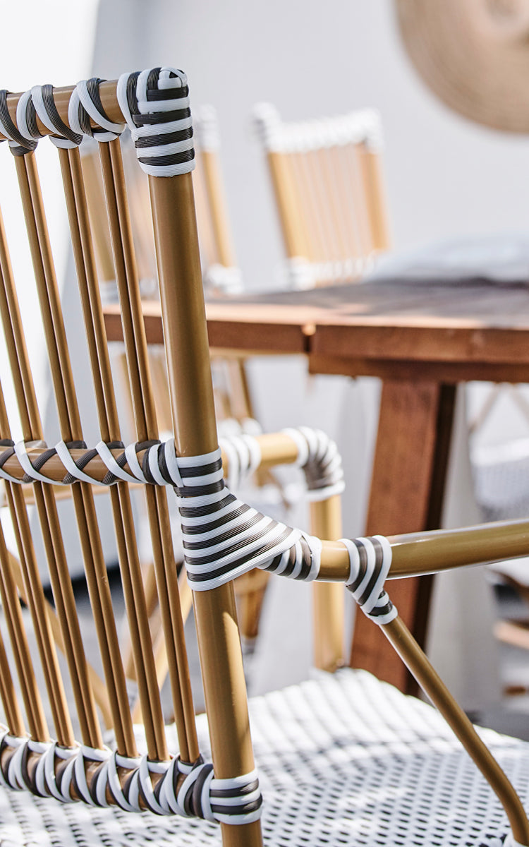 This is a close-up image of Monique Exterior Dining Armchair in white w cappuccino dot ArtFibre. Detail of the dot weave and armrest.