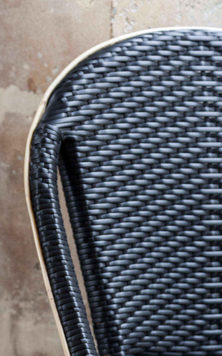 This is a close-up image of Sofie Dining Chair in black artfibre skin on rattan frame. Detail of the woven texture and frame construction.