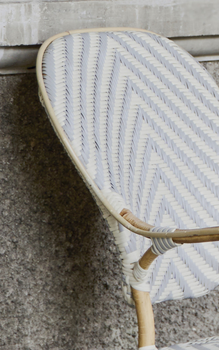 This is a close-up image of Isabell Dining Armchair in chevron Grey Ivory ArtFibre Skin on Rattan frame.