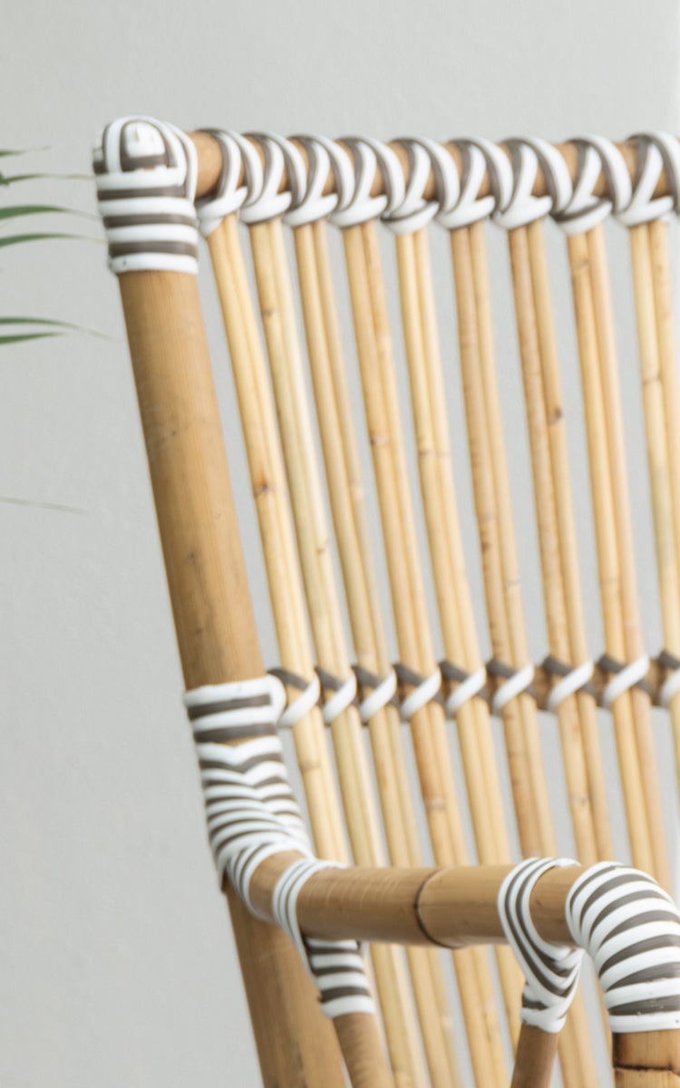 This is a close-up image of Monique Dining Armchair in white w cappuccino dot artfibre skin on rattan frame.