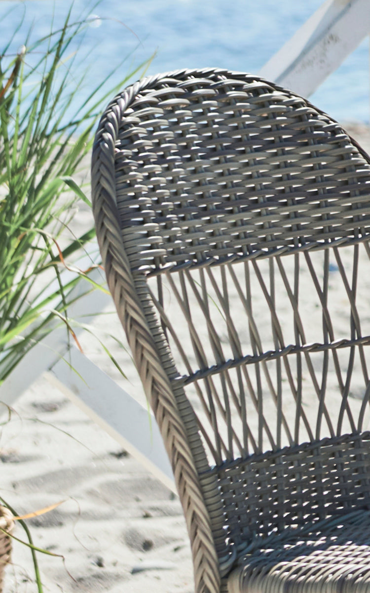 This is a close-up image of Ofelia Exterior Chair in antique grey artfibre aluminium. Detail of the rounded woven back and frame.