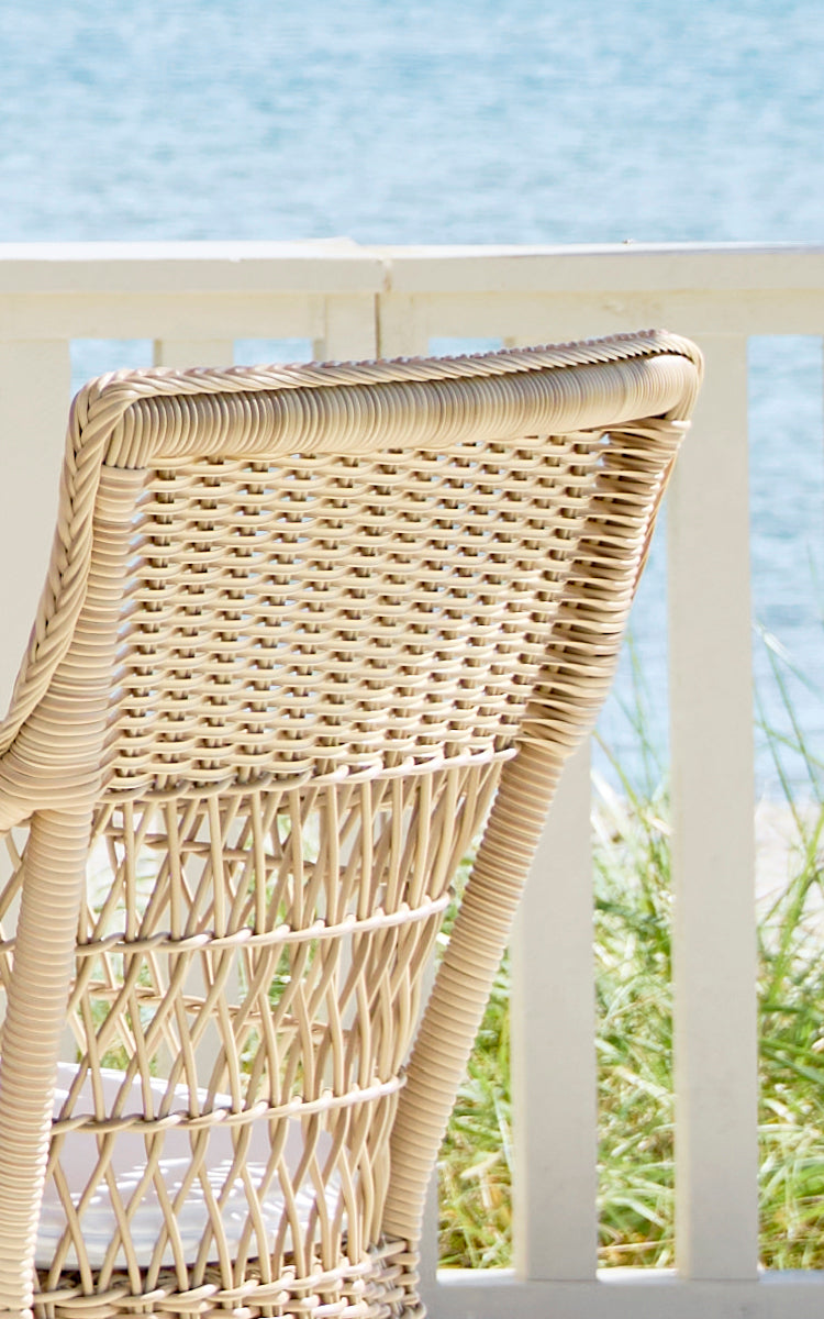 This is a close-up image of Marie Exterior Armchair in natural artfibre aluminium. Detail of the woven lattice back and armrest wrap.