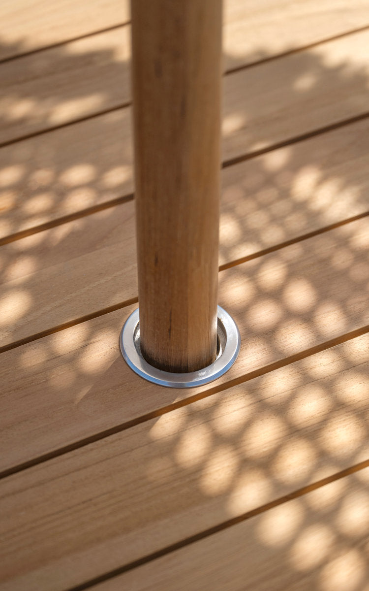 This is a close-up image of George Teak Table Ø120 cm in teak outdoor. Parasol pole in the tabletop insert.
