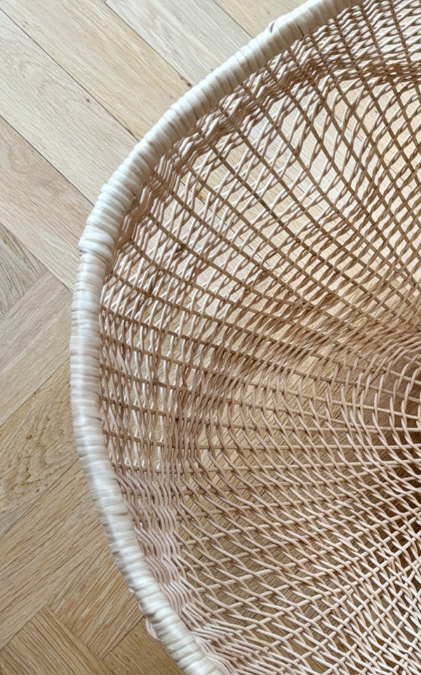 This is a close-up image of Folia Basket in natural core weave iron frame.