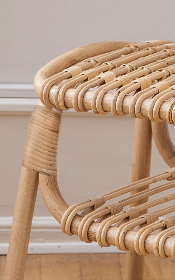 This is a close-up image of Machiya Stool in natural skin on rattan. Looped rattan seat weave and wrapped frame joints in warm tones.
