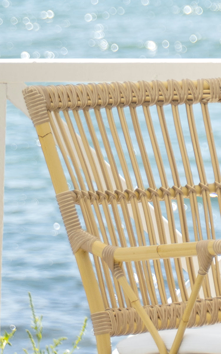This is a close-up image of Piano Exterior Dining Armchair in natural aluminium artfibre. Detail of the woven texture and frame construction.