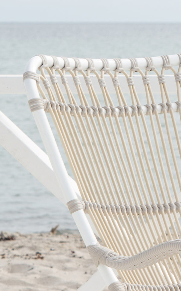This is a close-up image of Monet Exterior Rocking Chair in dove white aluminium artfibre. Detail of the looped arch backrest.