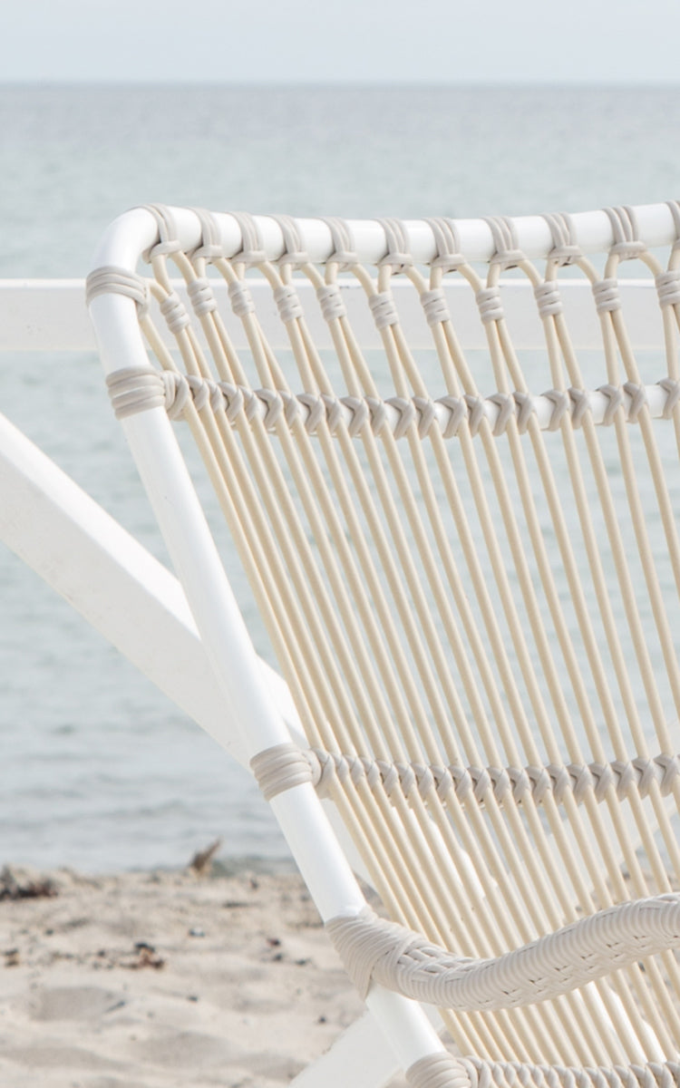 This is a close-up image of Monet Exterior Rocking Chair in dove white aluminium artfibre. Detail of the looped arch backrest.
