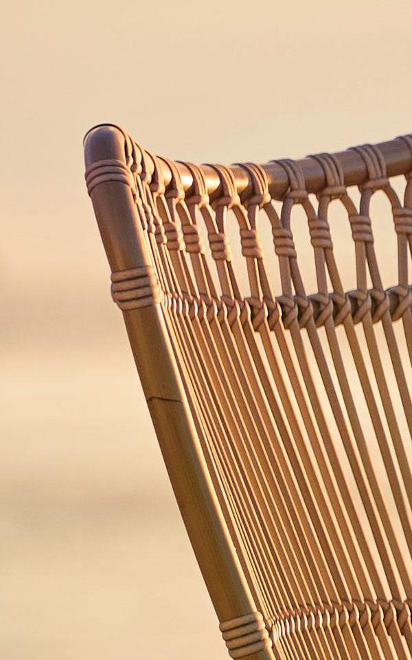 This is a close-up image of Monet Exterior Lounge Chair in antique aluminium artfibre. Detail of the looped arches and vertical rods.