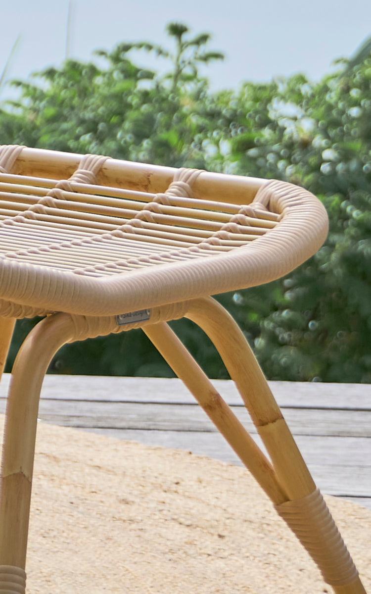 This is a close-up image of Monet Exterior Footstool in natural aluminium artfibre. Detail of the woven seat and splayed legs.