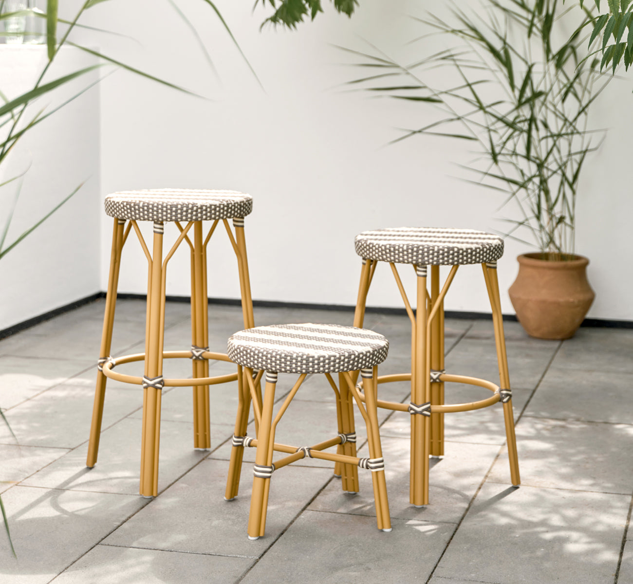 This is a lifestyle image of Simone Exterior Stool in almond aluminium frame striped cappuccino ivory artfibre. Styled in a bright interior setting.