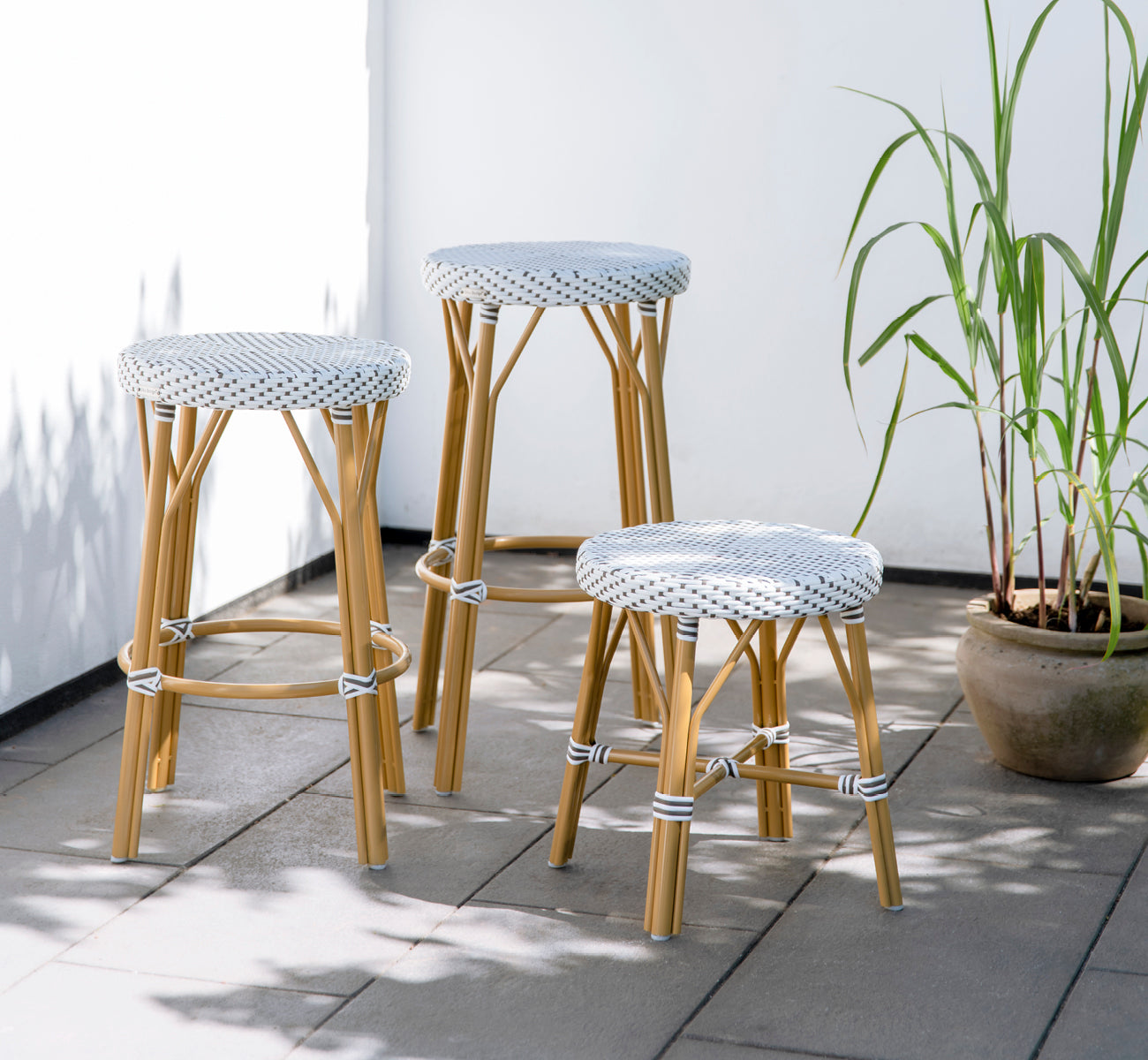 This is a lifestyle image of Simone Exterior Counter Stool in almond aluminium frame white w cappuccino dot artfibre.