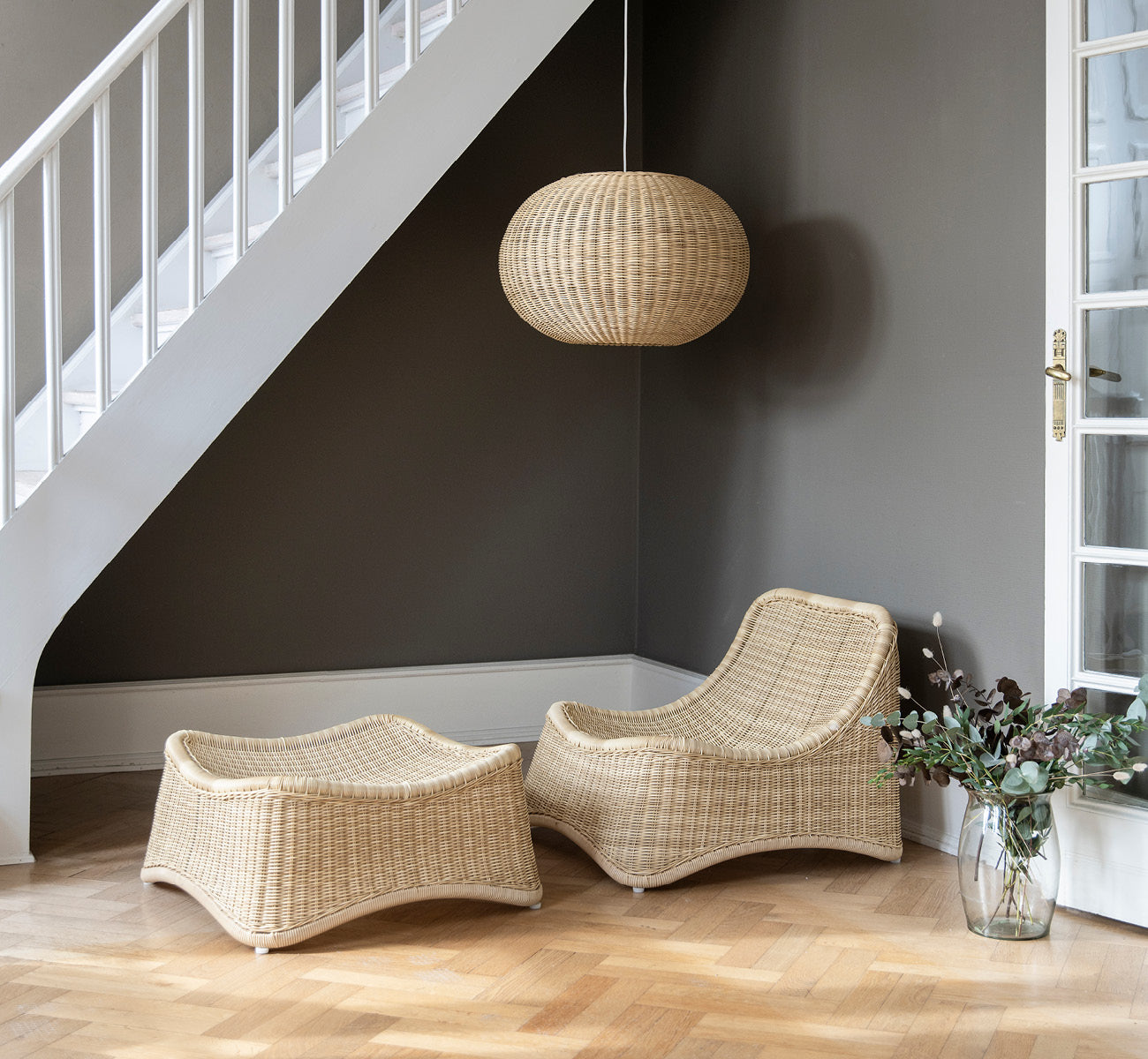 This is a lifestyle image of Chill Lounge Chair in natural core weave Rattan frame, in an elegant classical interior with ornate golden mouldings.