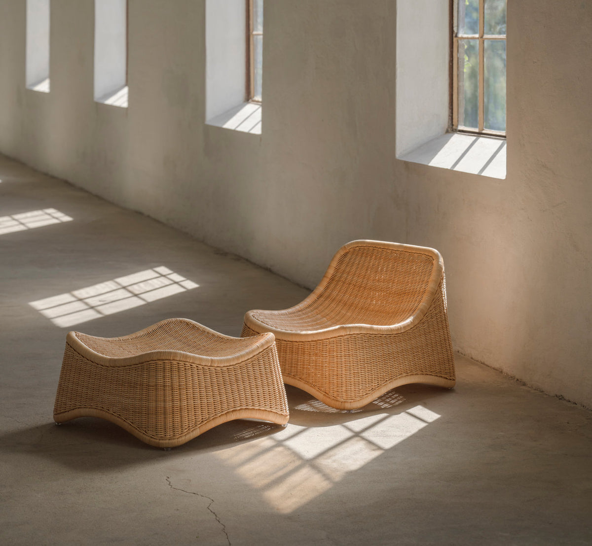 This is a lifestyle image of Chill Lounge Chair in natural core weave rattan frame. With matching footstool in sunlit room.