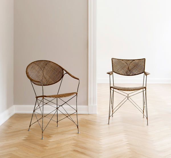 This is a lifestyle image of Funky Dining Chair in hazelnut rattan iron frame, in a bright interior with white panelled walls and herringbone parquet.