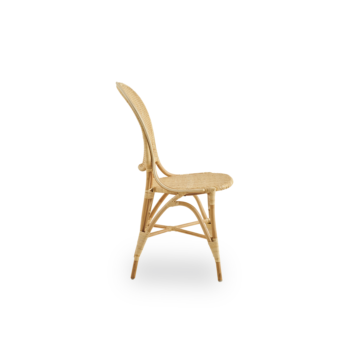 Plain side view of Rossini dining chair in natural rattan. Elegant wicker chair with round backrest in simple design. Handcrafted from high quality rattan.