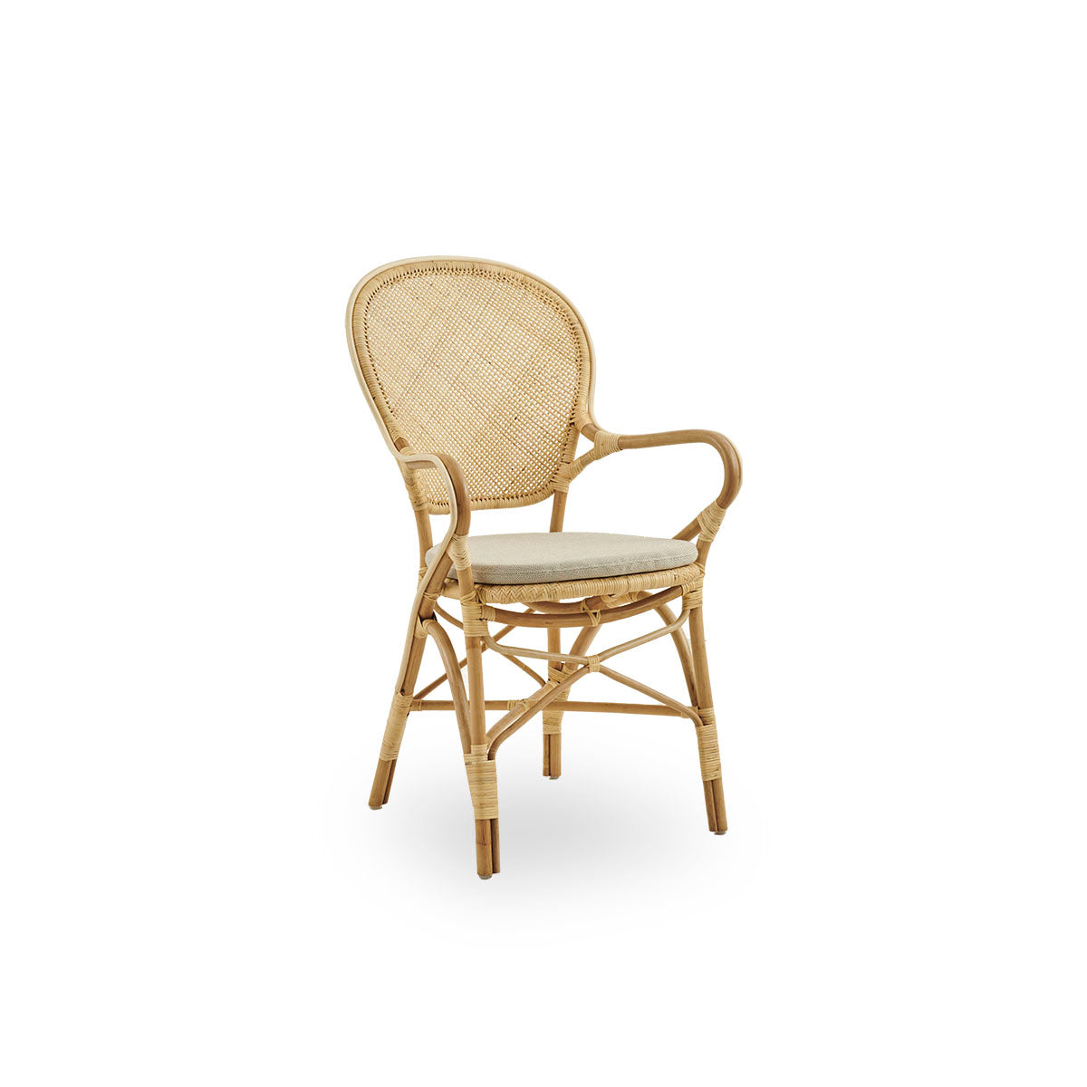 Side view of Rossini dining armchair made in natural rattan. Elegant wicker chair with round backrest and armrests in simple design. Handcrafted from high quality rattan.