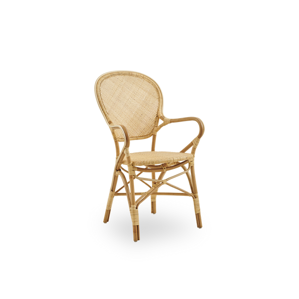 Side view of Rossini dining armchair made in natural rattan. Elegant wicker chair with round backrest and armrests in simple design. Handcrafted from high quality rattan.