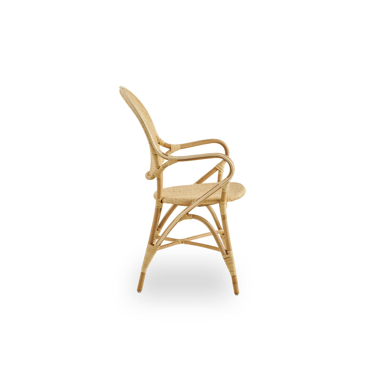 Plain side view of Rossini dining armchair made in natural rattan. Elegant wicker chair with round backrest and armrests in simple design. Handcrafted from high quality rattan.