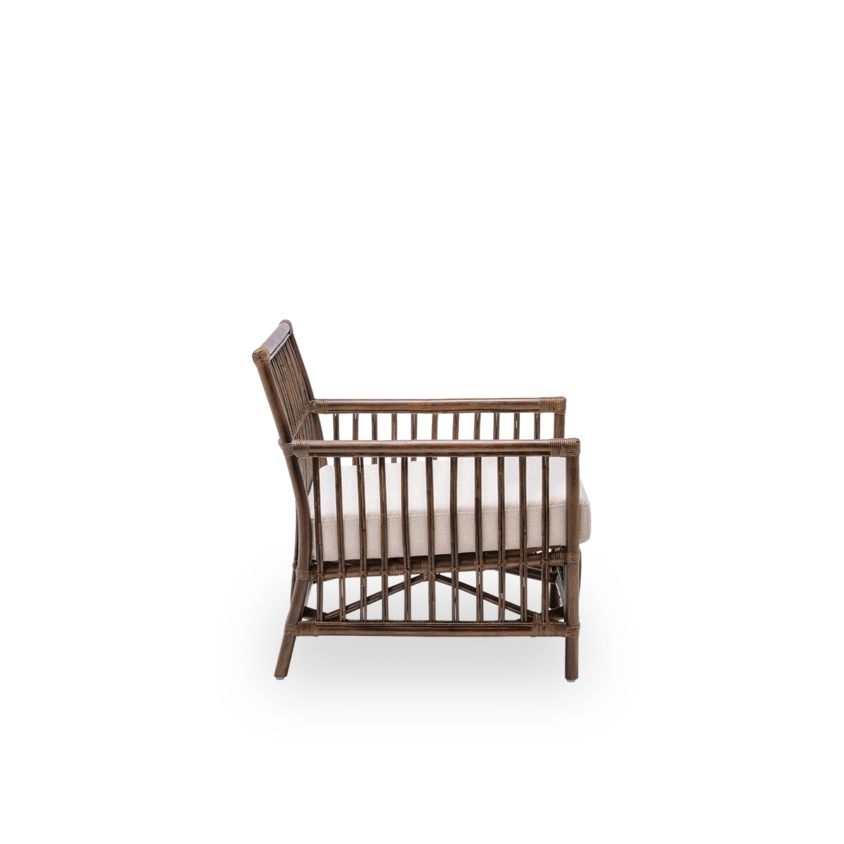 Plain side view of the Caroline lounge chair with seat cushion, in brown rattan. A simple and elegant Danish design whose detailed windings make it a quiet element in the room. Handcrafted from high-quality Indonesian rattan.