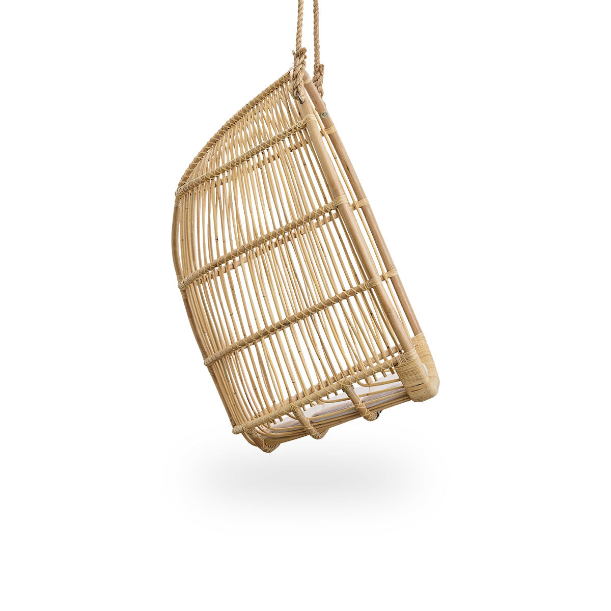Plain side view of Renoir hanging chair in Natural color handcrafted in high quality rattan. Soft, embracing shape suspended with strong rope.