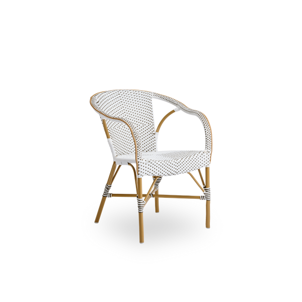 Side view of Madeleine outdoor dining armchair. Aluminium frame in almond color with seat and backrest woven with ArtFibre in brown with white dots.