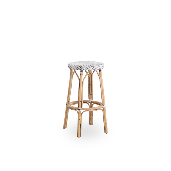 Side view of Simone barstool height 78 cm. Rattan frame with footrest, with fully woven round seat handcrafted in ArtFibre in white with brown dots pattern. Stackable barstool.