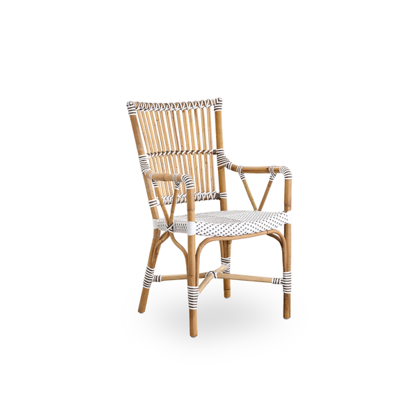 Side view of Monique dining armchair. Rattan frame with seat woven with ArtFibre in white with brown dots. Inspired by 1950s bistro design.