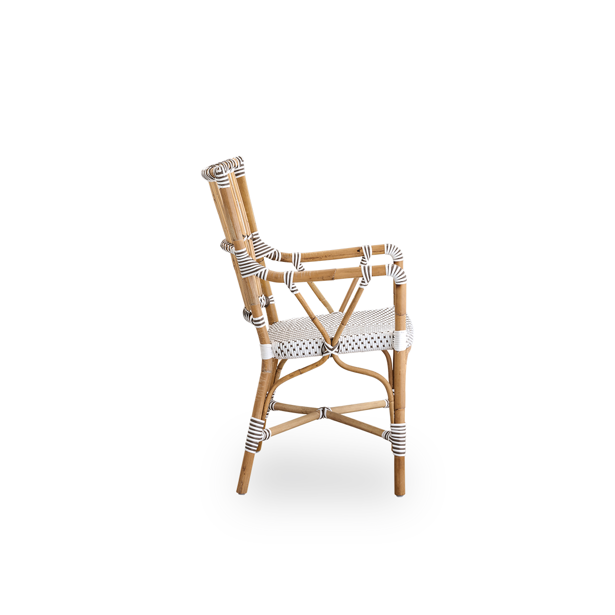 Plain side view of Monique dining armchair. Rattan frame with seat woven with ArtFibre in white with brown dots. Inspired by 1950s bistro design.