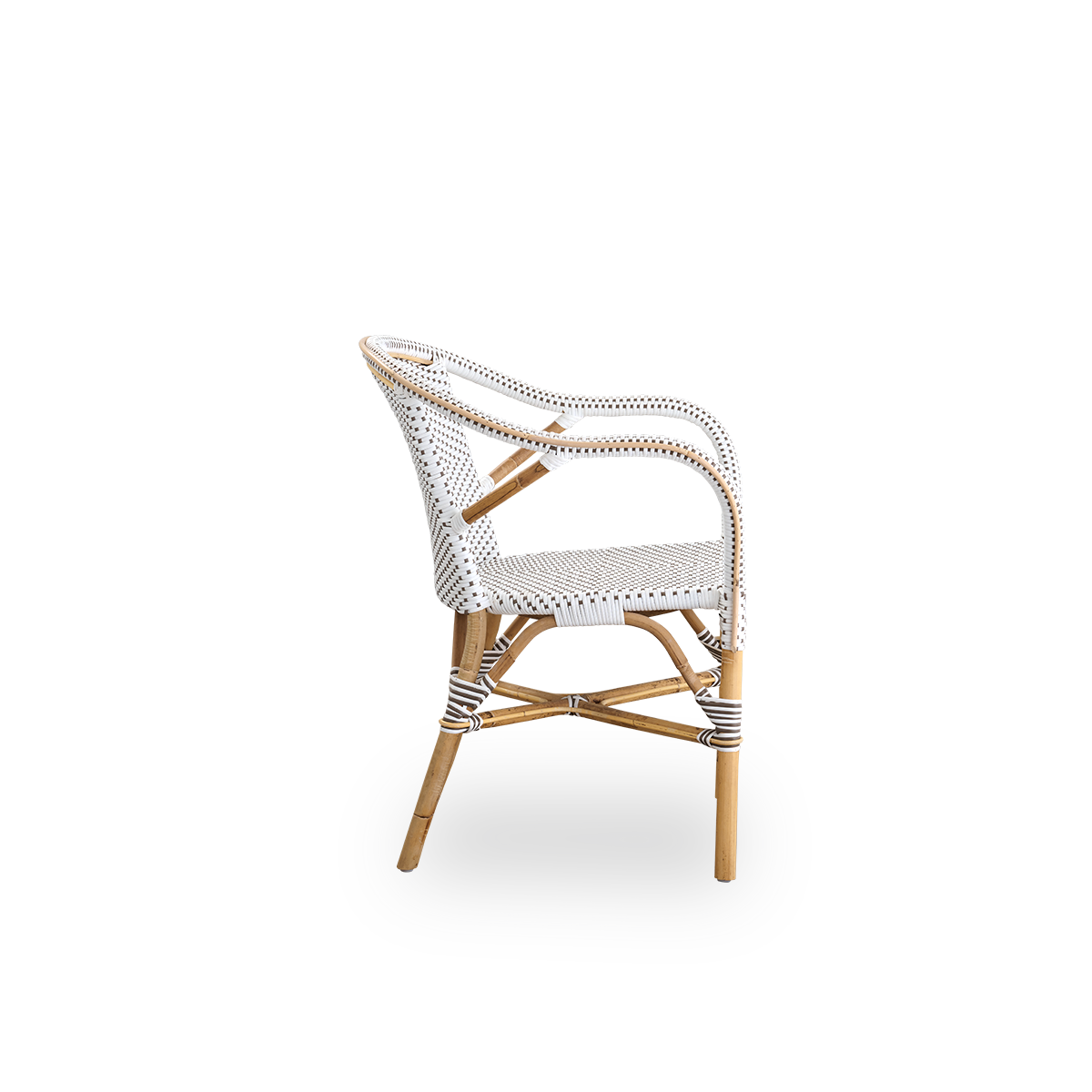 Plain side view of Madeleine dining armchair. Rattan frame with seat and backrest woven with ArtFibre in white with brown dots. Inspired by 1950s bistro design.