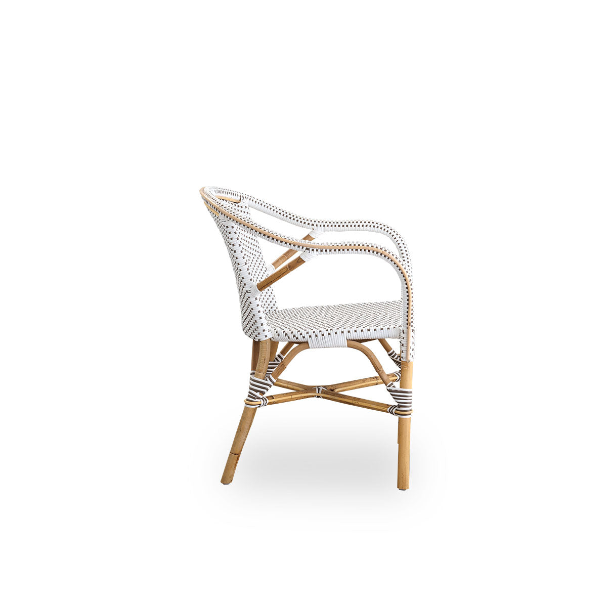 Plain side view of Madeleine dining armchair. Rattan frame with seat and backrest woven with ArtFibre in white with brown dots. Inspired by 1950s bistro design.