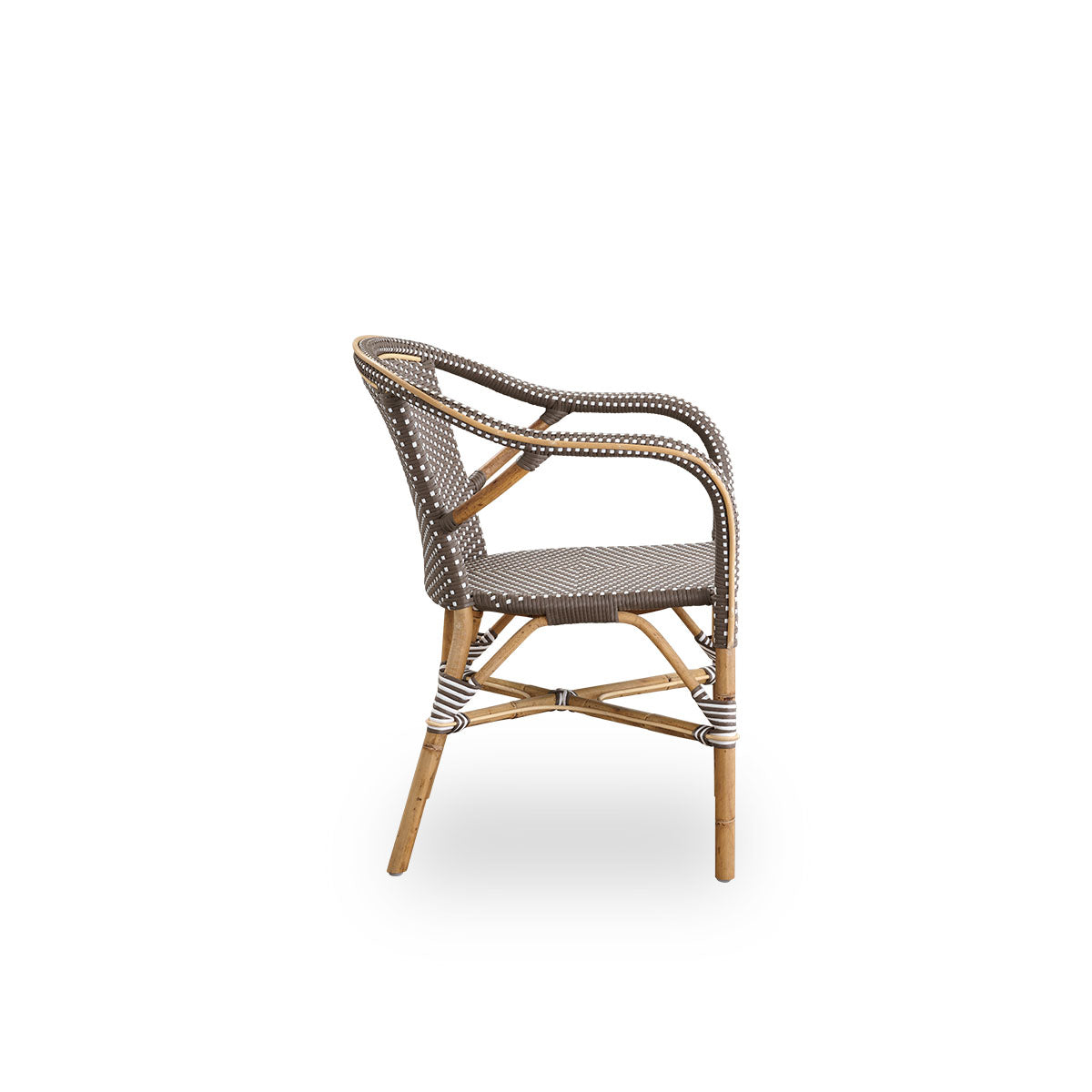 Plain side view of Madeleine dining armchair. Rattan frame with seat and backrest woven with ArtFibre in brown with white dots. Inspired by 1950s bistro design.