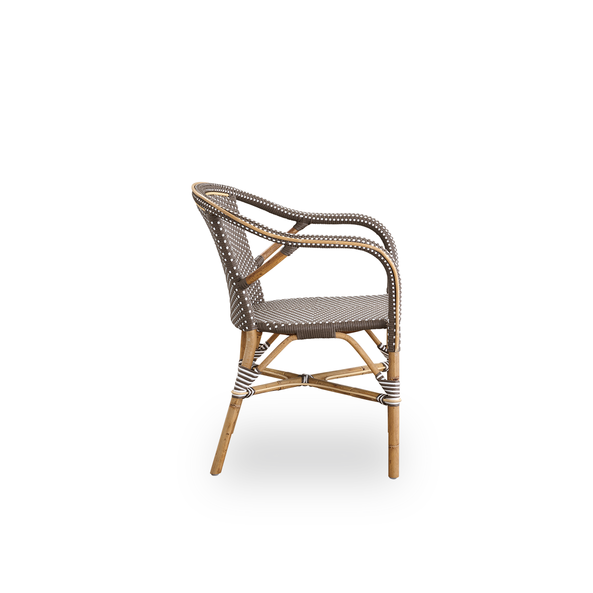 Plain side view of Madeleine dining armchair. Rattan frame with seat and backrest woven with ArtFibre in brown with white dots. Inspired by 1950s bistro design.