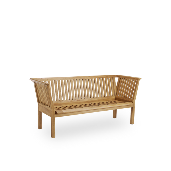 Side view of St Catherine outdoor teak bench designed by Arne Jacobsen, length 180 cm. Solid and durable bench handcrafted in chestnut brown high quality Indonesian teakwood certified ‘Indonesian Legal Wood’