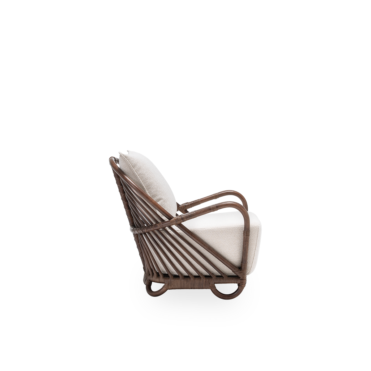Plain side view of the Charlottenborg lounge chair with seat and back cushions, in brown rattan. Designed by Arne Jacobsen in 1936 and part of Sika-Design's ICONS collection of reissued designer furniture. Handcrafted from high-quality Indonesian rattan.