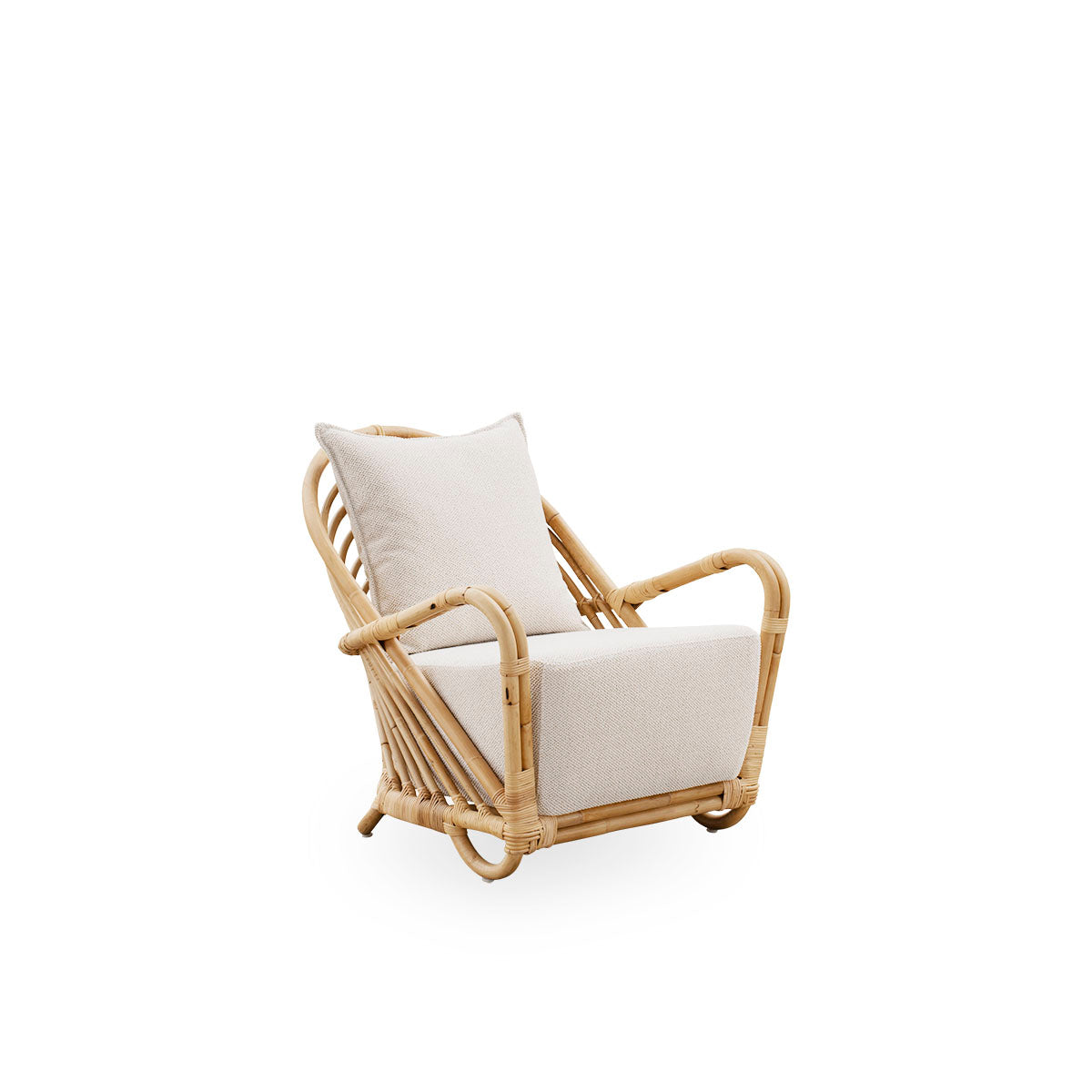 Side view of the Charlottenborg Lounge Chair in polished natural rattan, designed by Arne Jacobsen. The chair features a curved back and armrests integrated into the base, handcrafted from high quality Indonesian rattan.