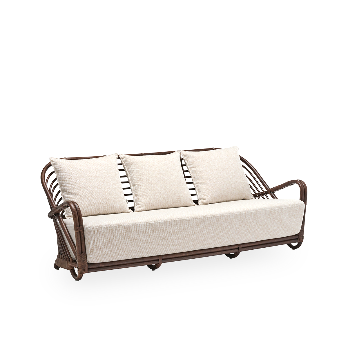 Side view of the Charlottenborg 3-seater sofa with seat and back cushions, in brown rattan. Originally designed by Arne Jacobsen in 1936, its gracefully curved backrest flows seamlessly into the armrests. Handcrafted in rattan.