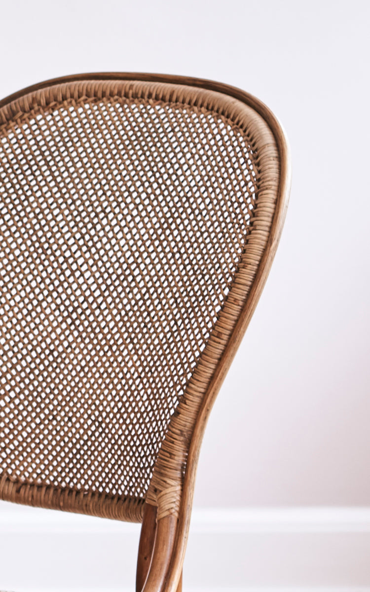 This is a close-up image of Rossini Dining Chair in antique rattan. Detailed view of the open cane weave backrest and bistro-style frame.