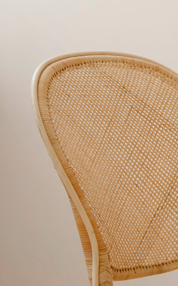 This is a close-up image of Rossini Dining Chair in natural rattan. Detailed view of the pale rattan cane weave back.