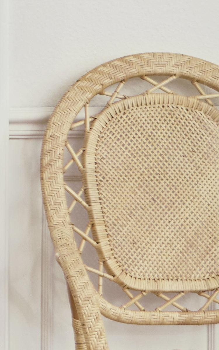 This is a close-up image of Romantica Dining Chair in natural rattan. The round backrest features a herringbone weave border and cane mesh center.