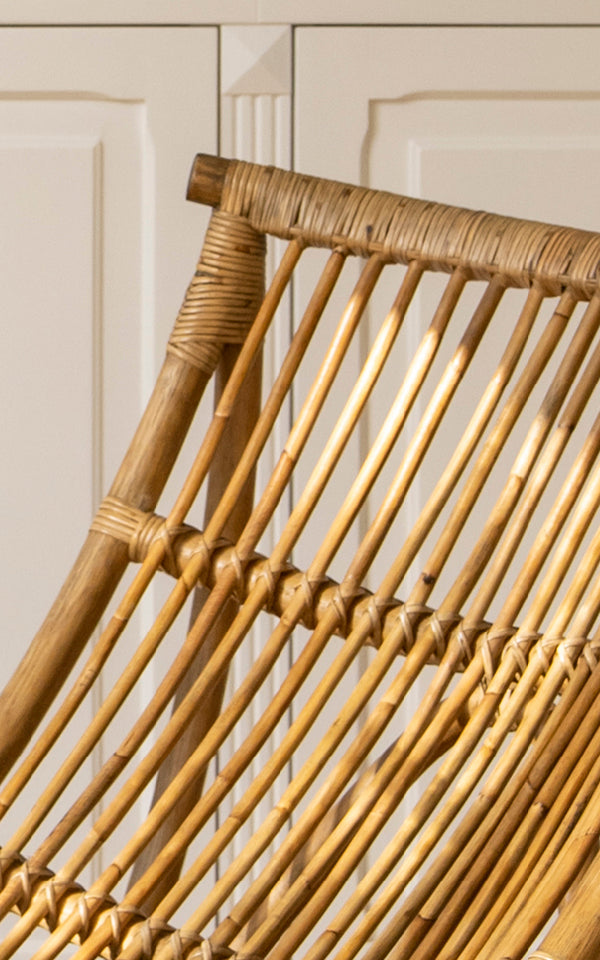 This is a close-up image of Michelangelo Daybed in antique rattan. Detail of the curved sculptural rattan rod construction and wrapped joints.