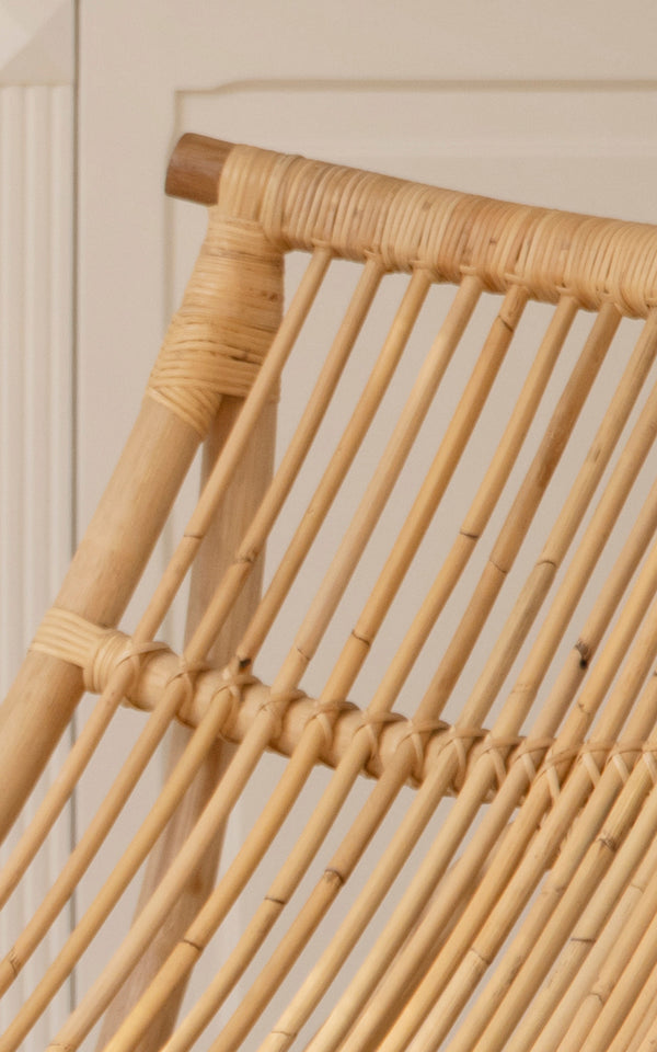 This is a close-up image of Michelangelo Daybed in natural rattan. Detail of the smooth bent rattan rods and woven binding at the joints.