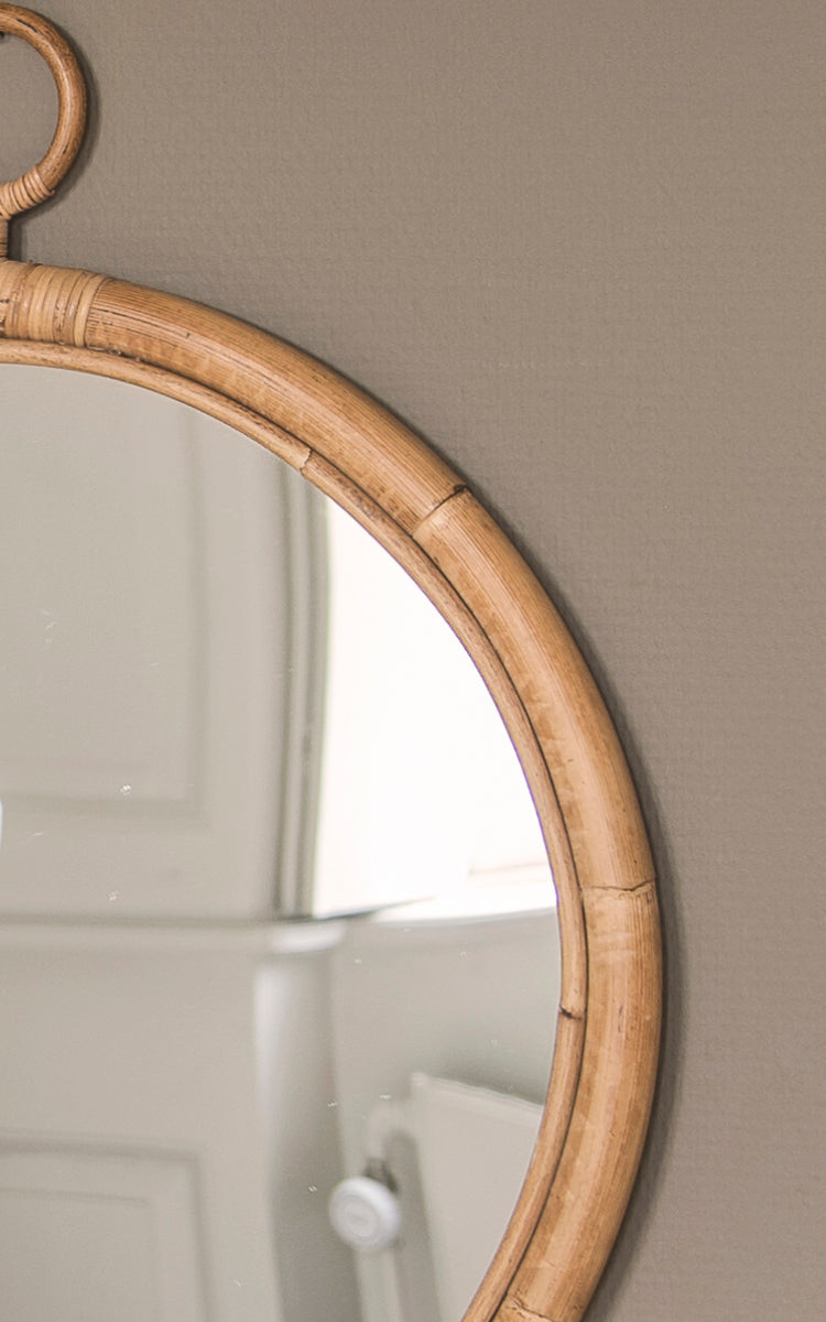 This is a close-up image of Ella Mirror O40cm in natural skin on rattan.