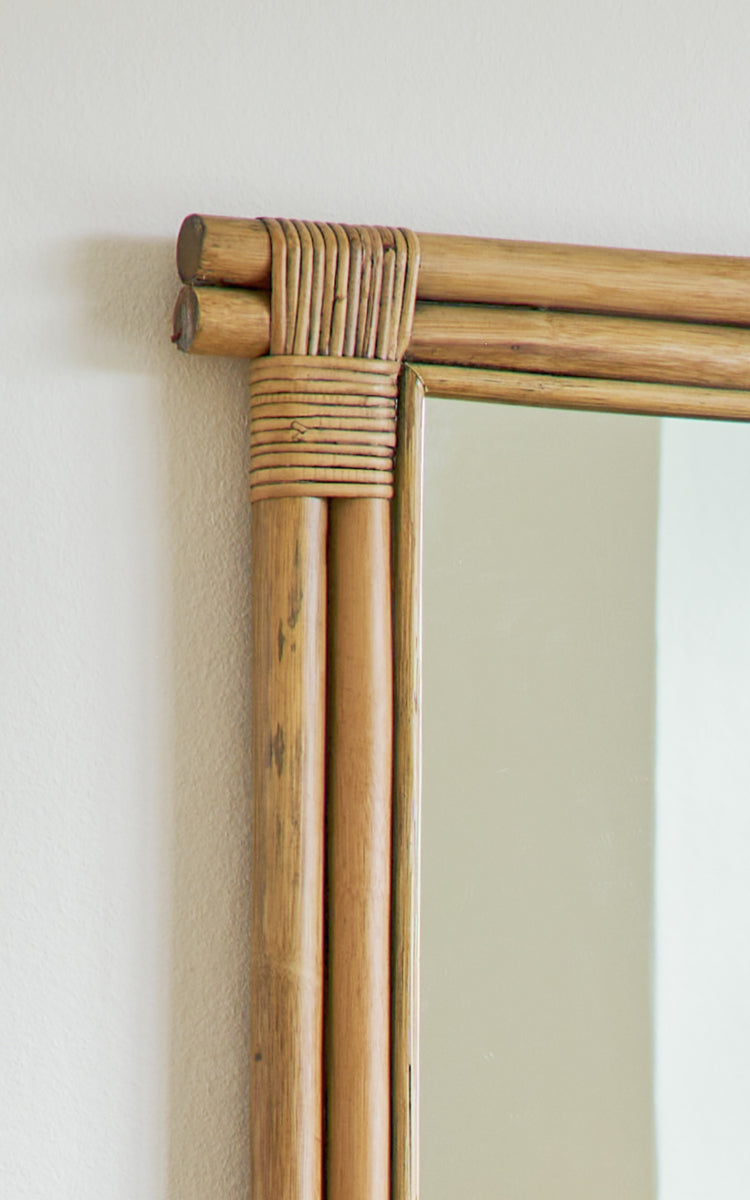 This is a close-up image of Rasmus Mirror 172 cm in antique rattan. Detail of the bundled rattan rods and wrapped corner of the mirror frame.