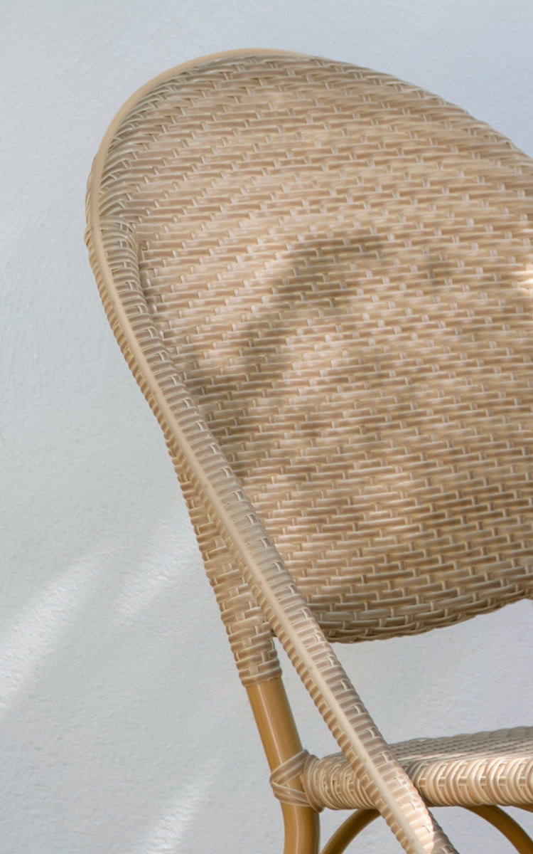 This is a close-up image of Sofie Exterior Dining Chair in almond aluminium frame natural ArtFibre. Detail of the woven ArtFibre seat.