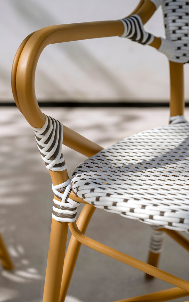 This is a close-up image of Isabell Exterior Dining Armchair in almond aluminium frame white w cappuccino dot artfibre. Wrapped armrest.