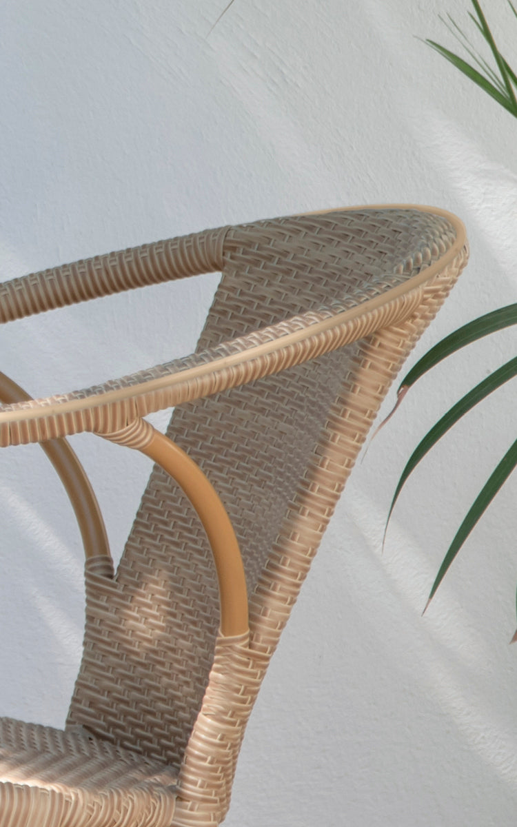 This is a close-up image of Madeleine Exterior Dining Chair in almond aluminium frame natural ArtFibre. Fine cross-weave texture and curved frame.