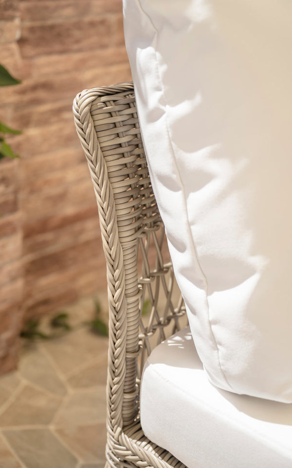 This is a close-up image of Mona Exterior Modular Sofa-Center Module in antique grey artfibre aluminium. Woven armrest with white cushion.