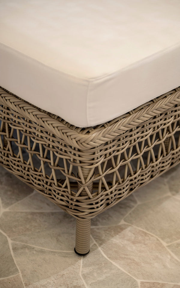 This is a close-up image of Mona Exterior Modular Sofa-Pouf Module in antique grey artfibre aluminium. Woven pouf edge with white cushion.